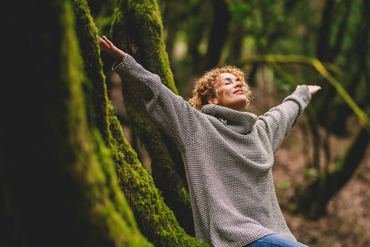 Overjoyed woman enjoying in beautiful forest