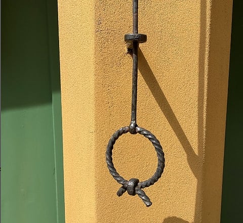 One of the unique wrought iron doorbell pull outside of an apartment door in Fuggerei