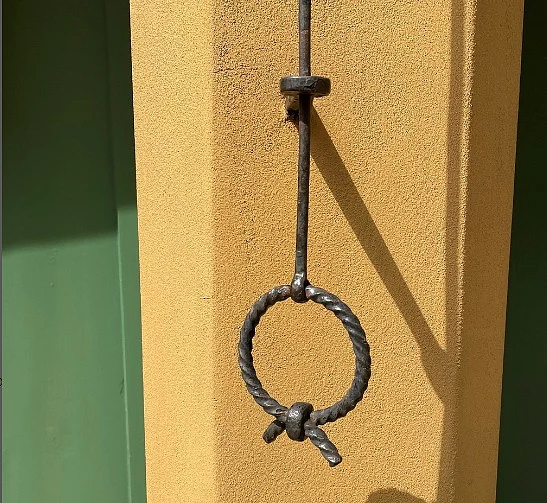 One of the unique wrought iron doorbell pull outside of an apartment door in Fuggerei