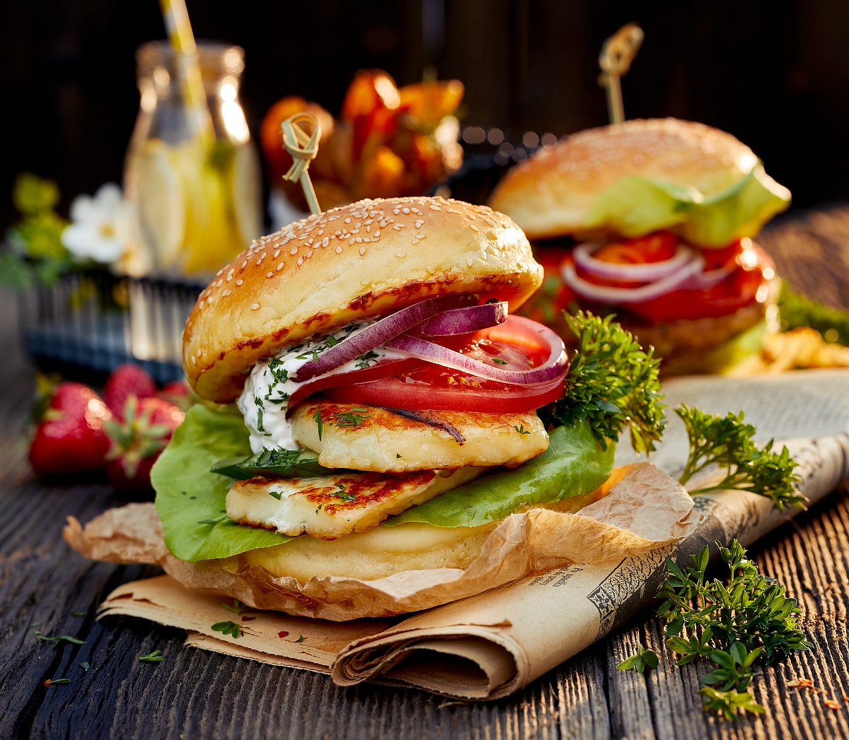 Vegetarian burger with grilled halloumi cheese, lettuce, tomato, cucumber and onion with yoghurt mint