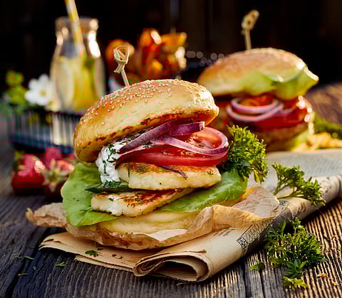 Vegetarian burger with grilled halloumi cheese, lettuce, tomato, cucumber and onion with yoghurt mint