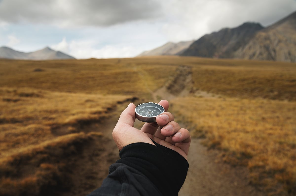 Mans hand holding a magnetic compass 