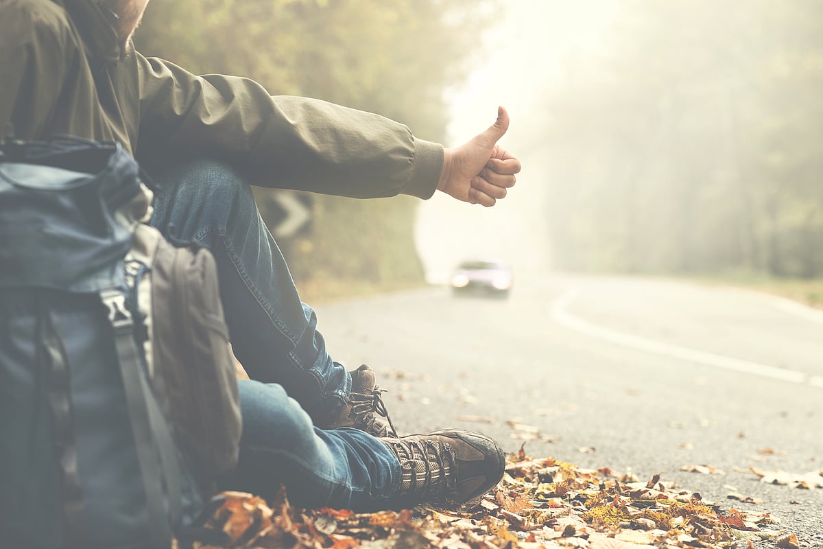 Man hitchhiking on a mountain road