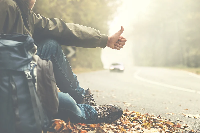 Man hitchhiking on a mountain road