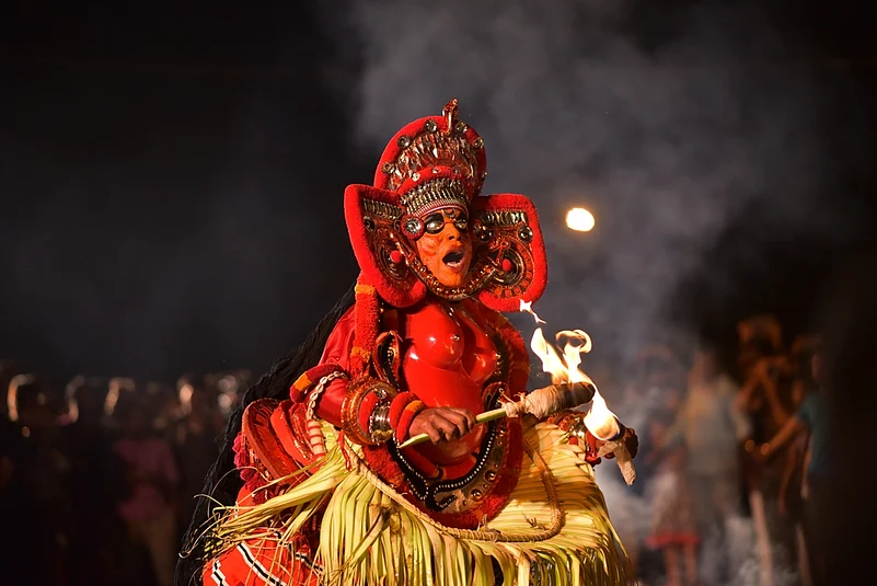 A theyyam artist performing with fire in Thiruvananthapuram