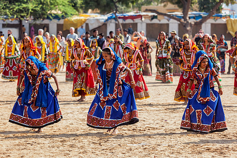 Rajasthani girls in traditional outfits dancing at annual Pushkar Mela