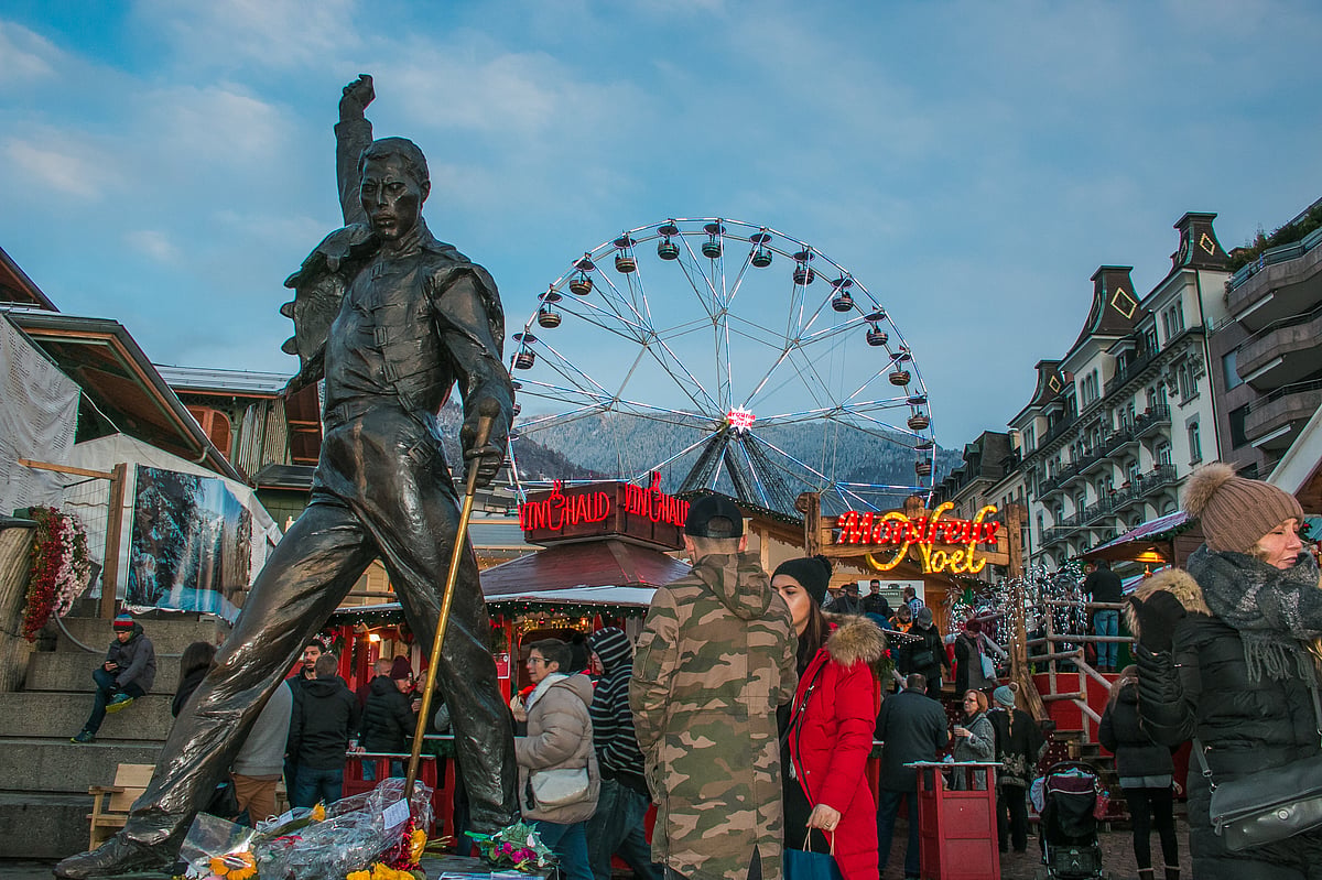 Freddie Mercury statue on waterfront of Geneva Lake and Christmas market in the background, Geneva