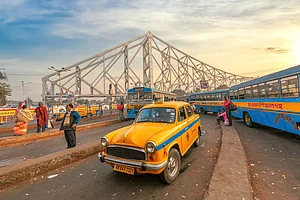 Roop_Dey/Shutterstock : The quintessential yellow taxi waits for passengers near Howrah Bridge