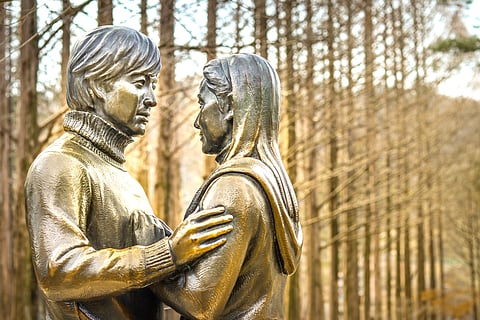 The Winter Sonata statue represents the main characters from the Korean drama series "Winter Sonata." The statue is located at one end of the metasoquoia lane on Nami Island, South Korea