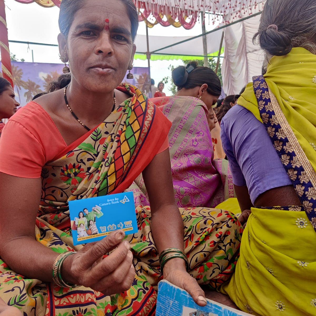 A village woman showing her debit card and passbook