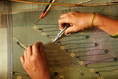 An artisan unwinding silk threads