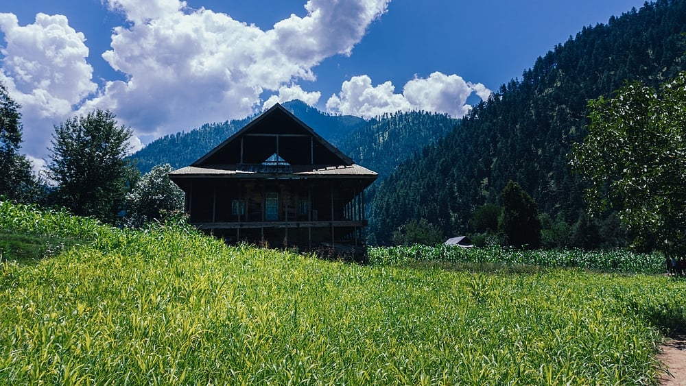 A serene river meanders amidst majestic mountains in Keran Valley
