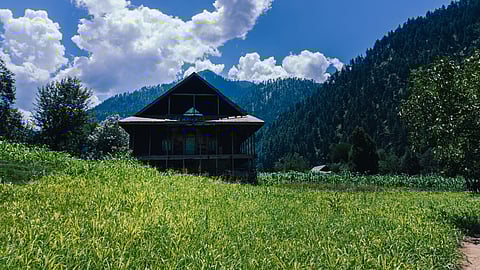 A serene river meanders amidst majestic mountains in Keran Valley