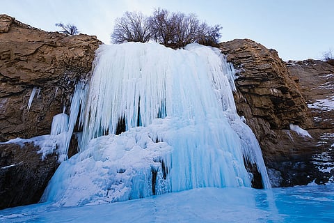 Amidst the icy embrace of the Chadar trek, a frozen waterfall stands as a testament to nature's enduring power, its cascading waters transformed into a spectacle of ice and light. —Leh, Ladakh