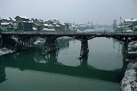 In winter, the partially frozen Dal Lake is as black and sludgy as an oil slick