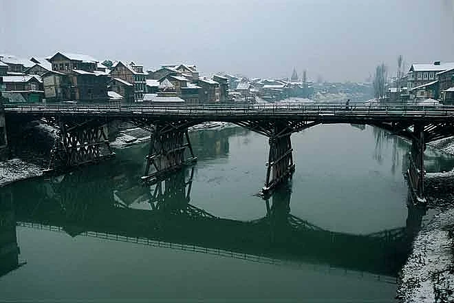 In winter, the partially frozen Dal Lake is as black and sludgy as an oil slick
