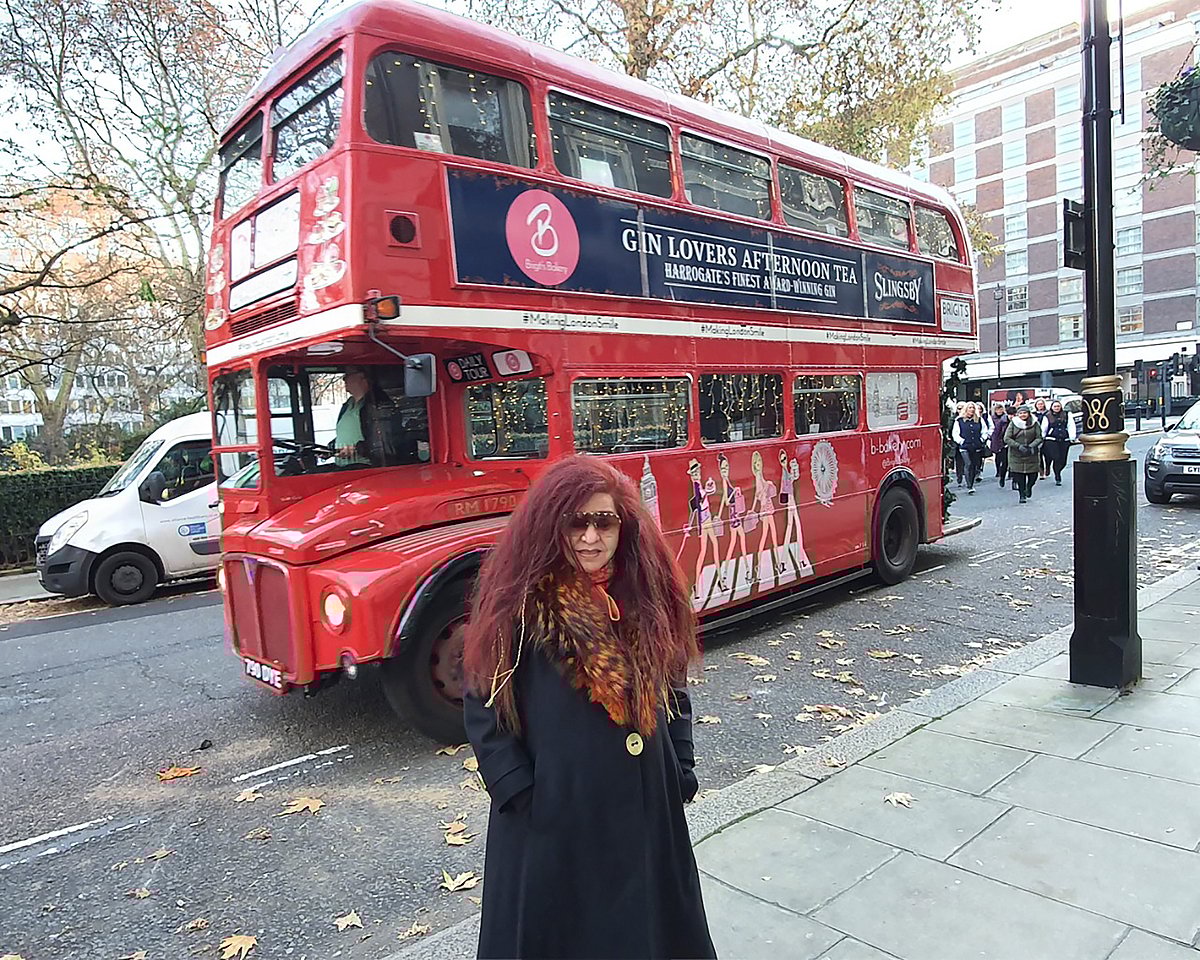 Husain posing in front of Londons double-decker bus