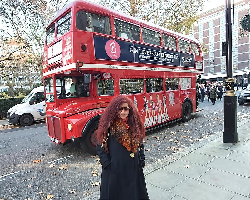 Husain posing in front of Londons double-decker bus