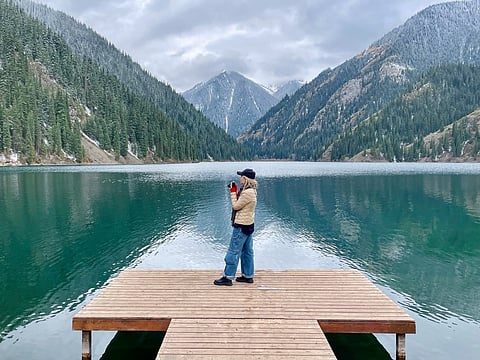 A tourist on the pier at Kolsai lake in Kazakhstan 