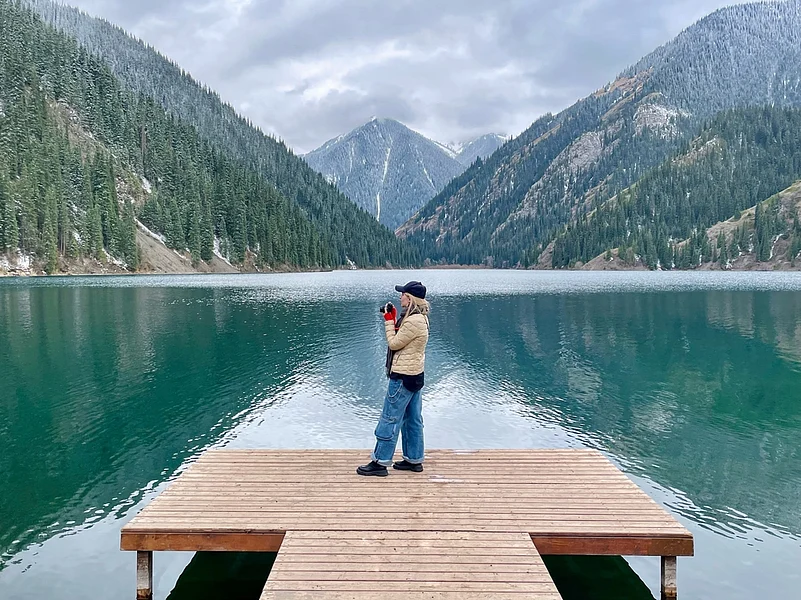 A tourist on the pier at Kolsai lake in Kazakhstan