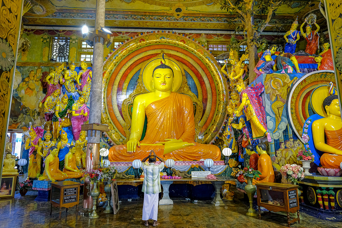 A man praying in the Gangaramaya Temple