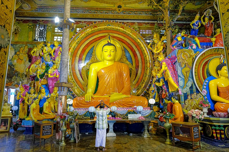 A man praying in the Gangaramaya Temple