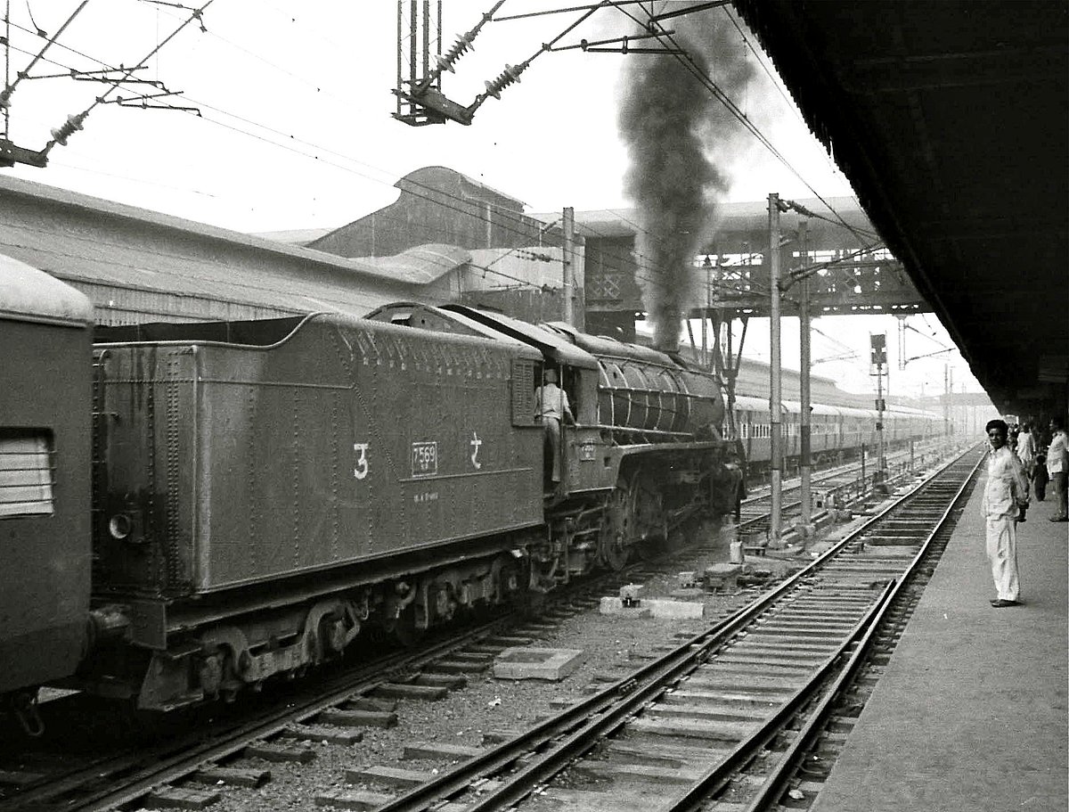 A steam engine train leaving the station in 1980