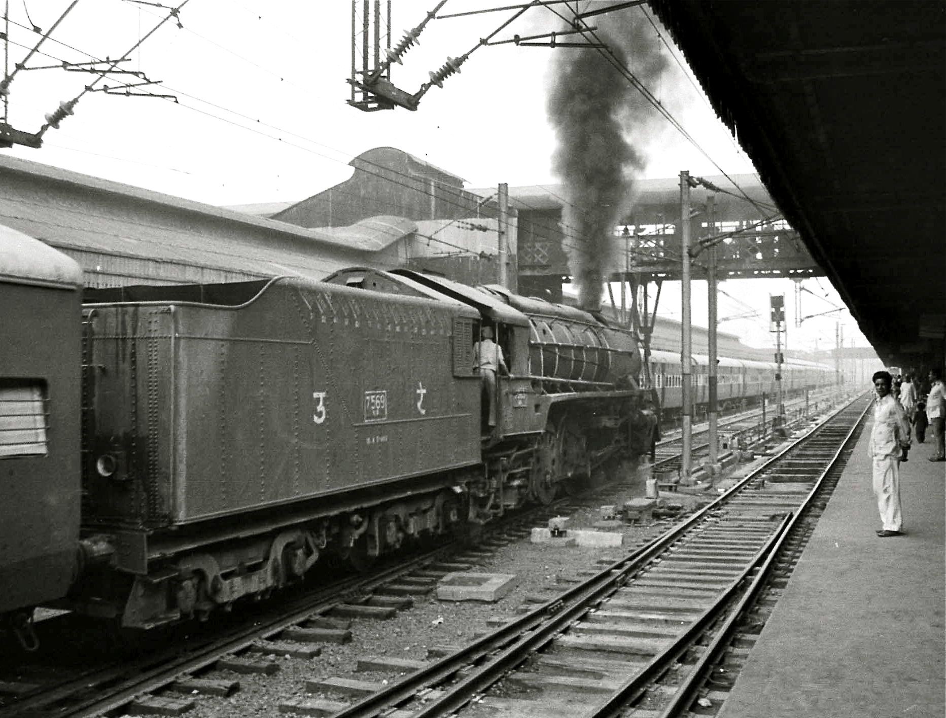 A steam engine train leaving the station in 1980