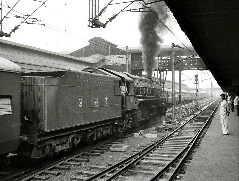 A steam engine train leaving the station in 1980