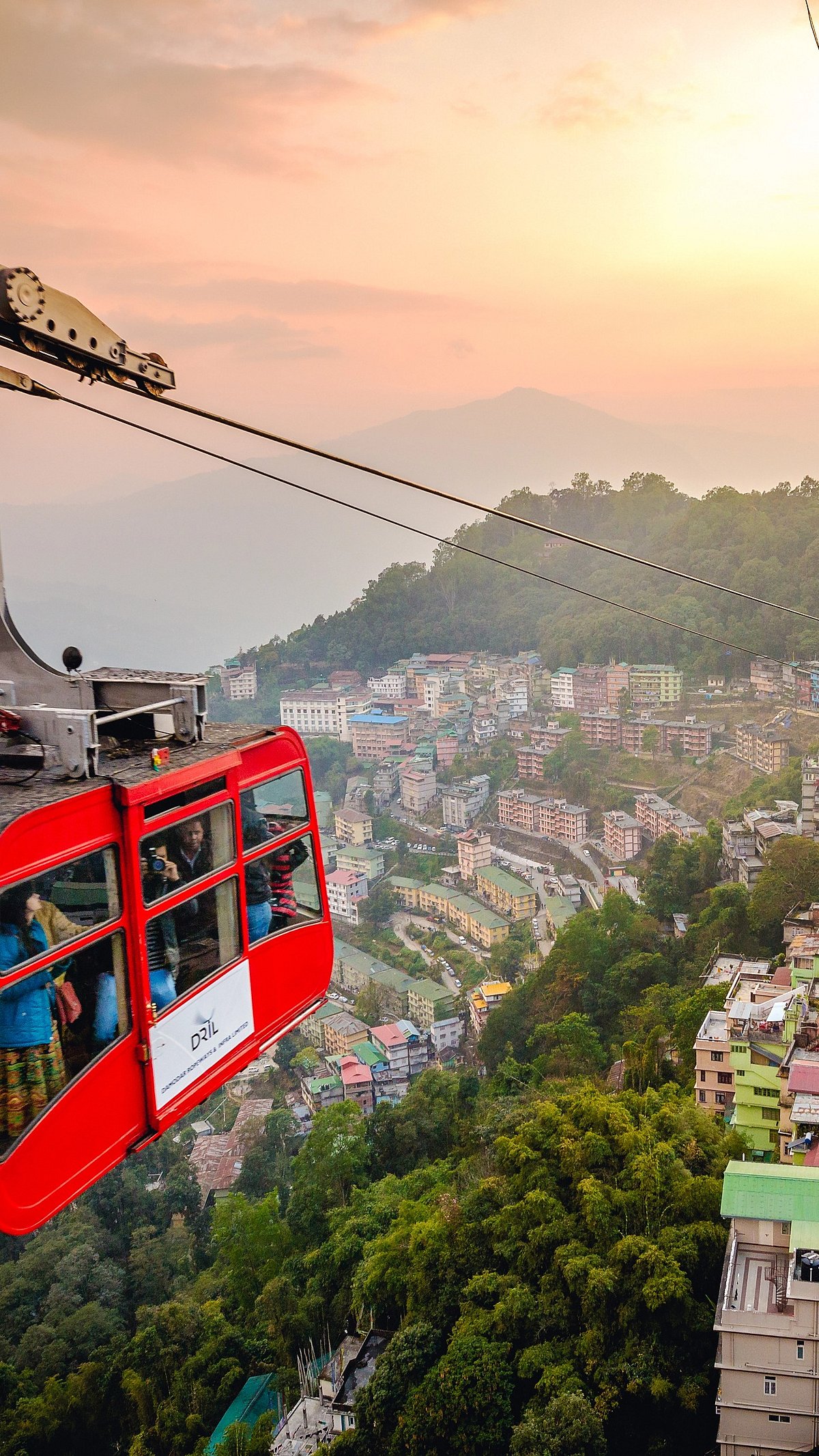 Shutterstock : Tourists enjoy a Gondola ride over Gangtok city during golden hour