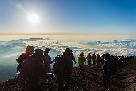 Hikers gather during sunrise on the Mt. Fuji summit