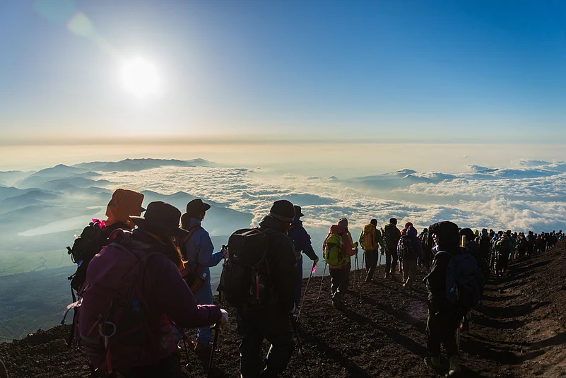 Hikers gather during sunrise on the Mt. Fuji summit