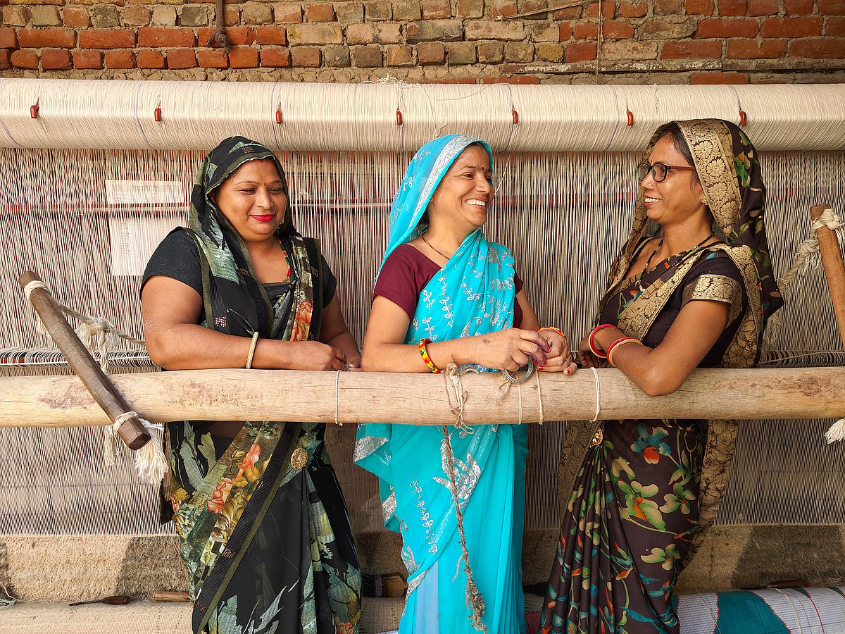 A group of women posing in front of their handloom