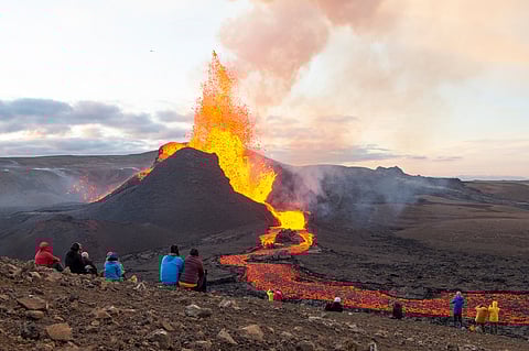 Tourists watching a volcanic eruption in Iceland