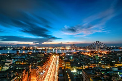 mitra kountik/Shutterstock : A lit up Howrah Bridge over the Hooghly River in Kolkata