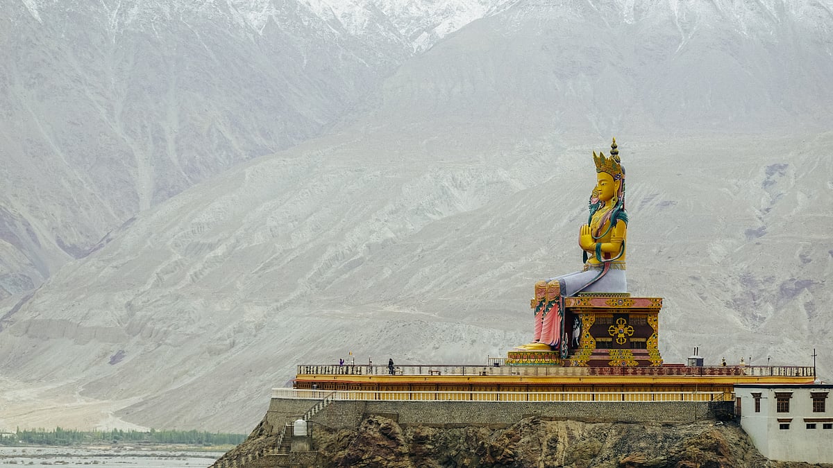 The Maitreya Buddha statue with Himalaya mountains in the background from Diskit Monastery or Diskit Gompa, Nubra valley, Leh Ladakh