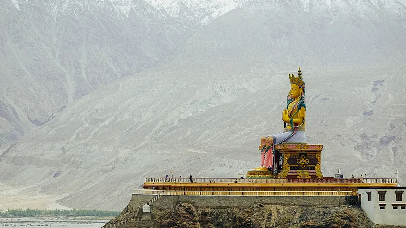 The Maitreya Buddha statue with Himalaya mountains in the background from Diskit Monastery or Diskit Gompa, Nubra valley, Leh Ladakh