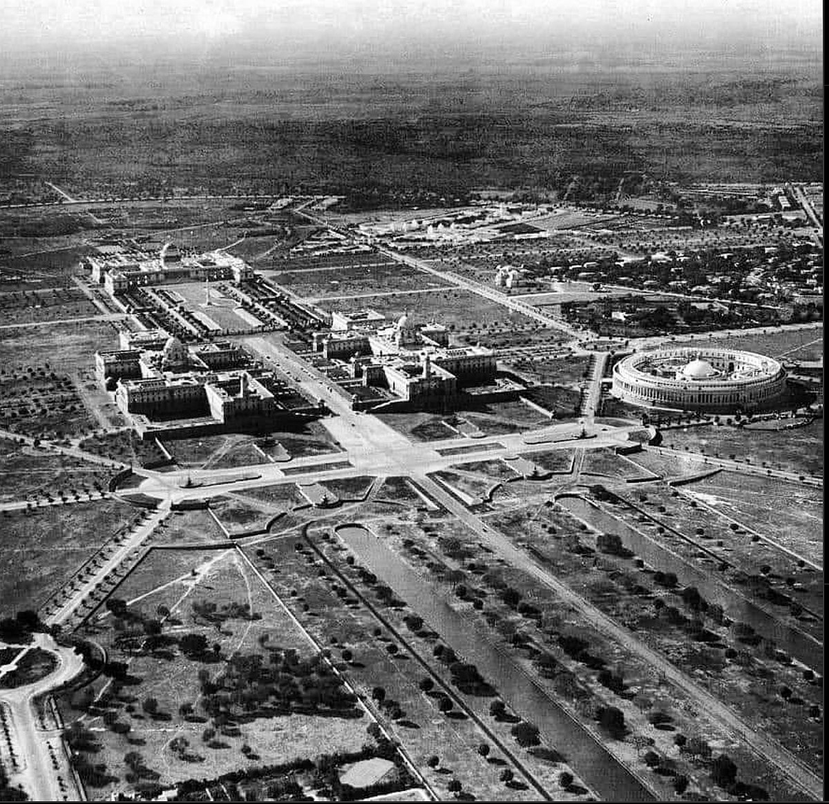 An aerial view of New Delhi, shot in 1930. We see the Presidents House at the top left, the North Block, the South Block, and the Parliament House on the right.