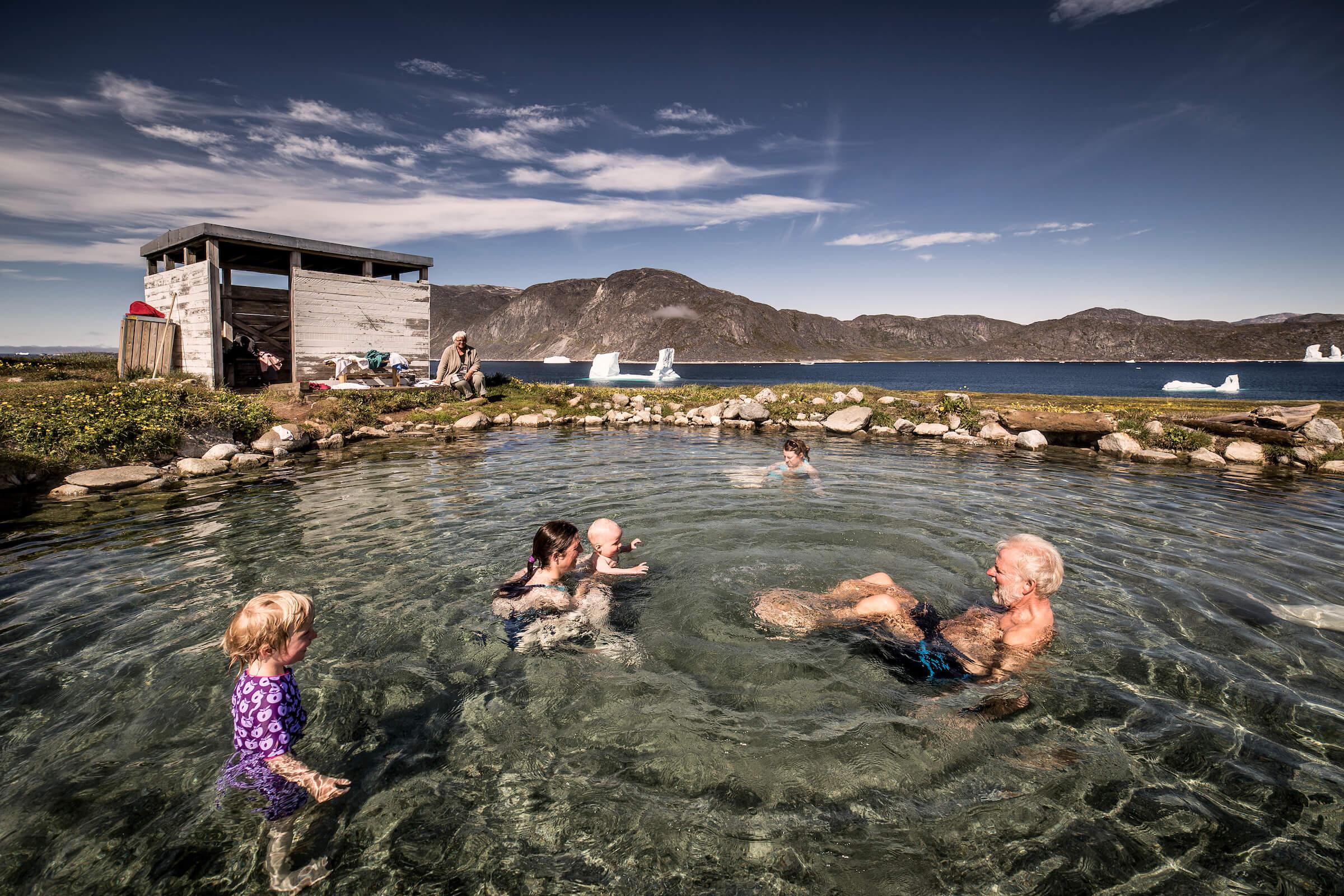 A family enjoys a swim at the Uunartoq hot pool