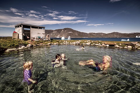 A family enjoys a swim at the Uunartoq hot pool