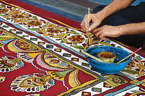An artist at work on his traditional kalamkari painting