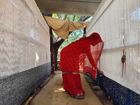Prem checking the threads of a handloom
