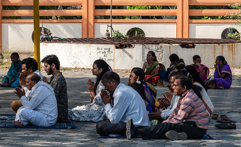 A group of Indian pilgrims sit in prayer at the Buddhist pilgrimage site of Deekshabhoomi