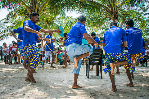 Men performing traditional local dance on tropical island beach