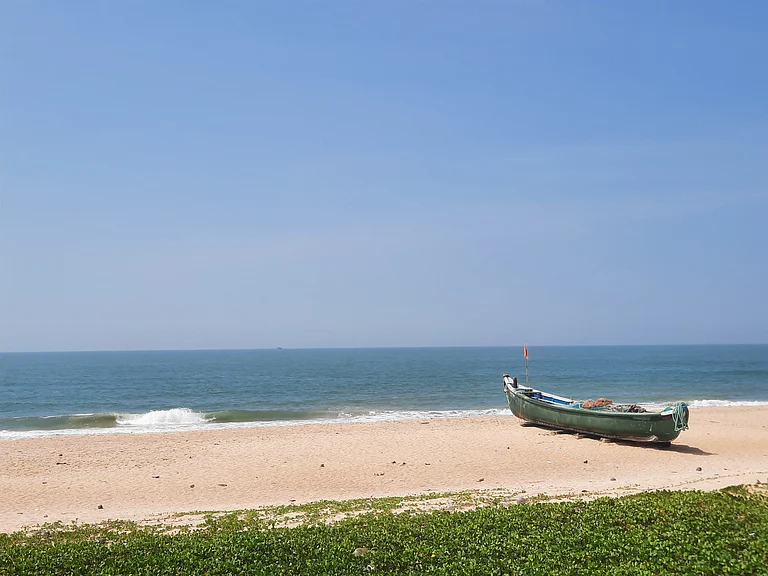 A traditional boat overlooks the Arabian Sea at a beach - Waquar Habib