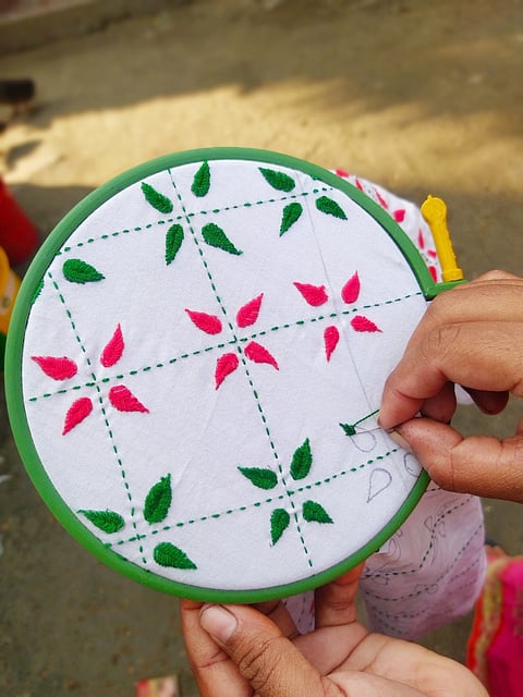 A woman making design on a Nakshi Kantha