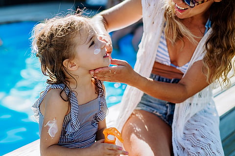 Mother applies sun screen to her kid