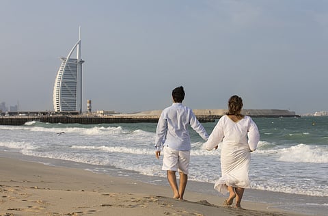 Couple walking on a beach in Dubai