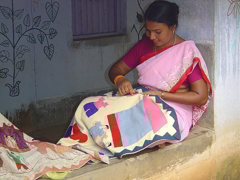 A Santhal tribeswoman sewing