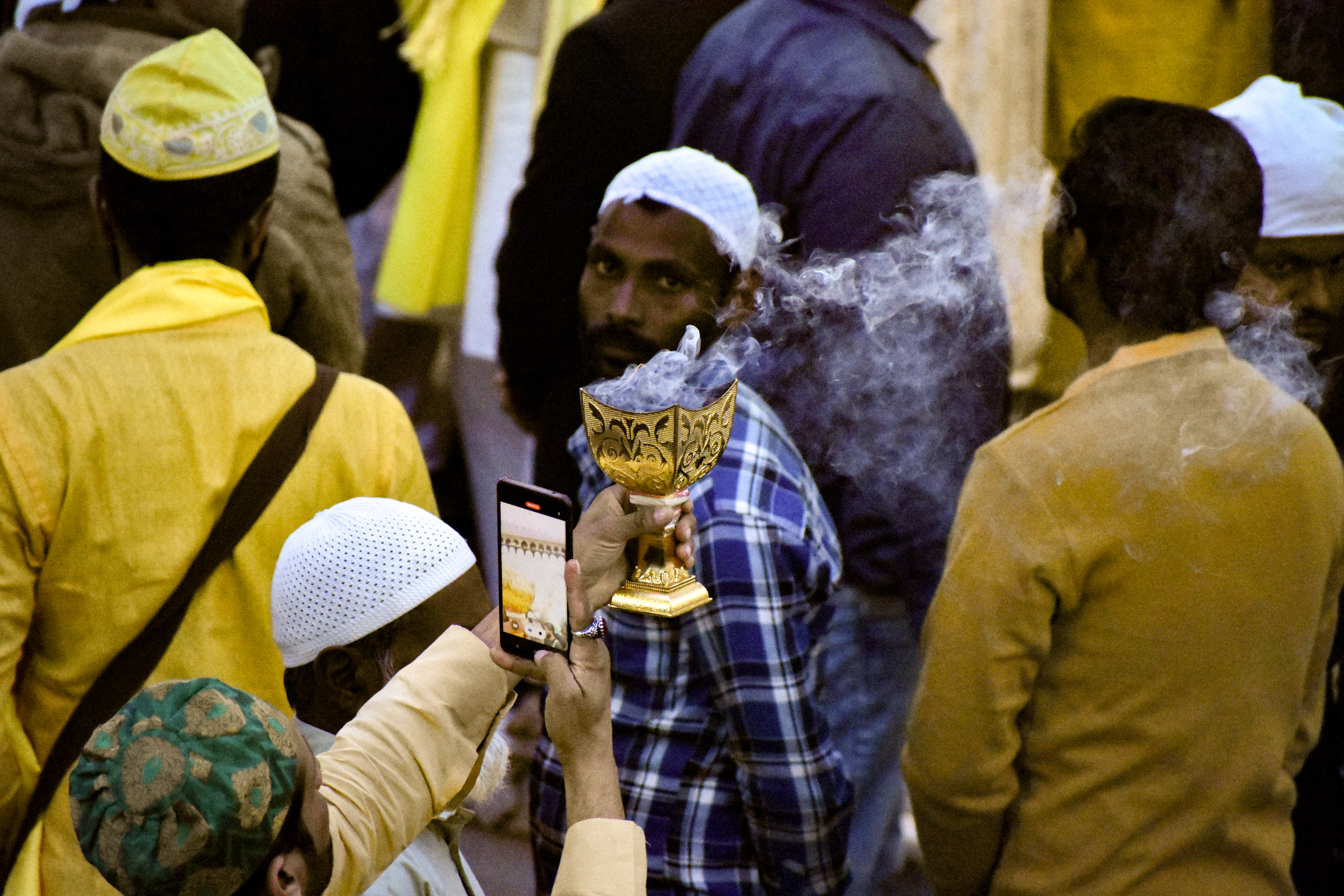A man hold a scented chalice with coal during the ceremony of Roshni ki Dua